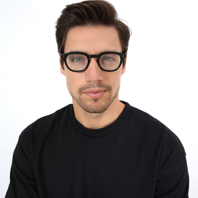 Model with brown hair combed sideways wearing Slope Optical Black Optical
