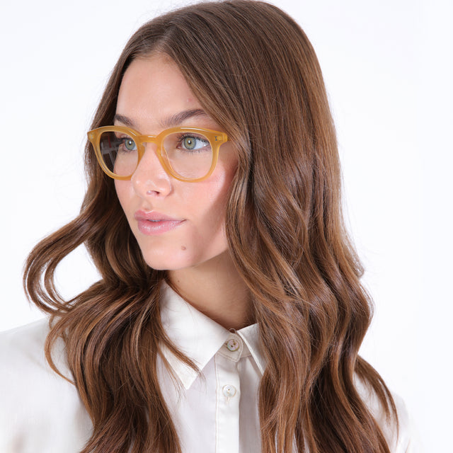 Brunette model with curled hair wearing Slope Optical Blond Optical