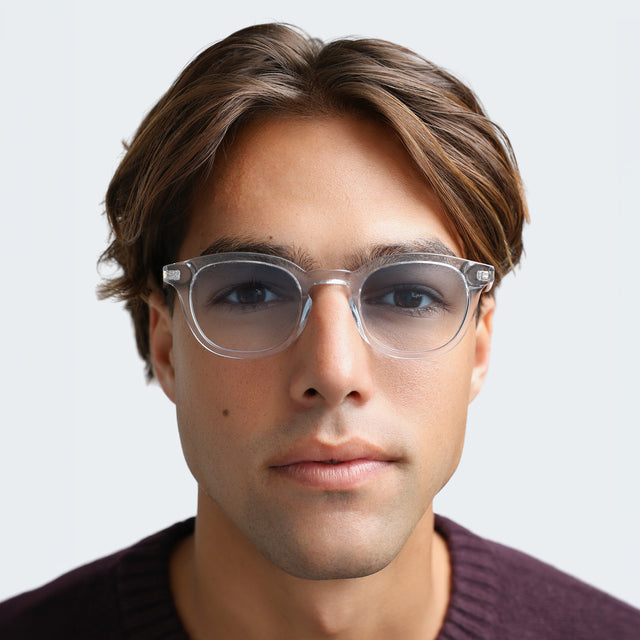 Man in a plum sweatshirt wearing Slope Sunglasses Clear with Blue Gradient See Through