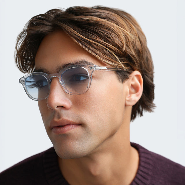 Another angle of man in a plum sweatshirt wearing Slope Sunglasses Clear with Blue Gradient See Through