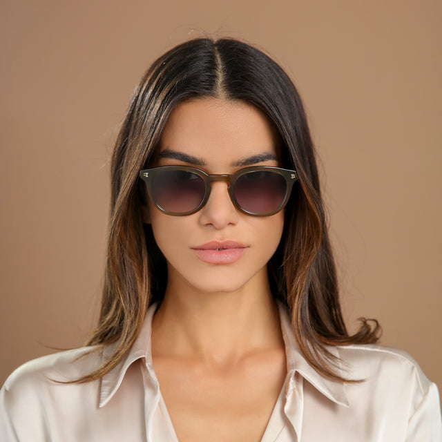 Brunette woman in a cream silk blouse wearing Slope Sunglasses Olive with Grey Gradient