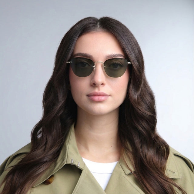 Woman in a trench coat wearing Sorrento Sunglasses Gold with Olive Flat