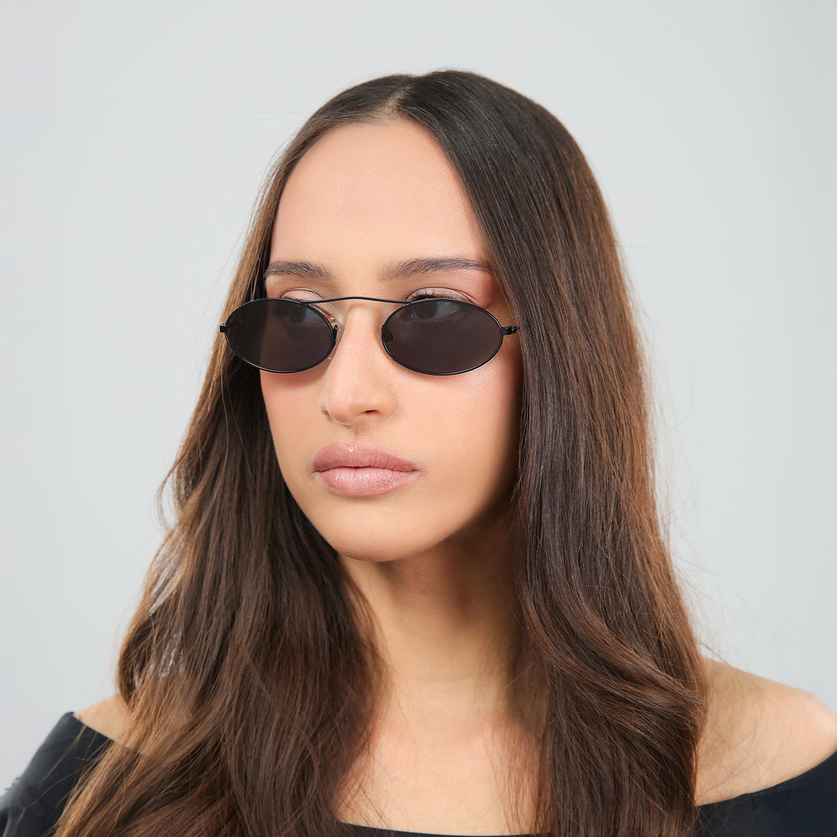 Woman wearing Sydney Sunglasses in Matte Black with Grey lenses, side profile, Another angle of woman with brown hair in an off-the-shoulder blouse
