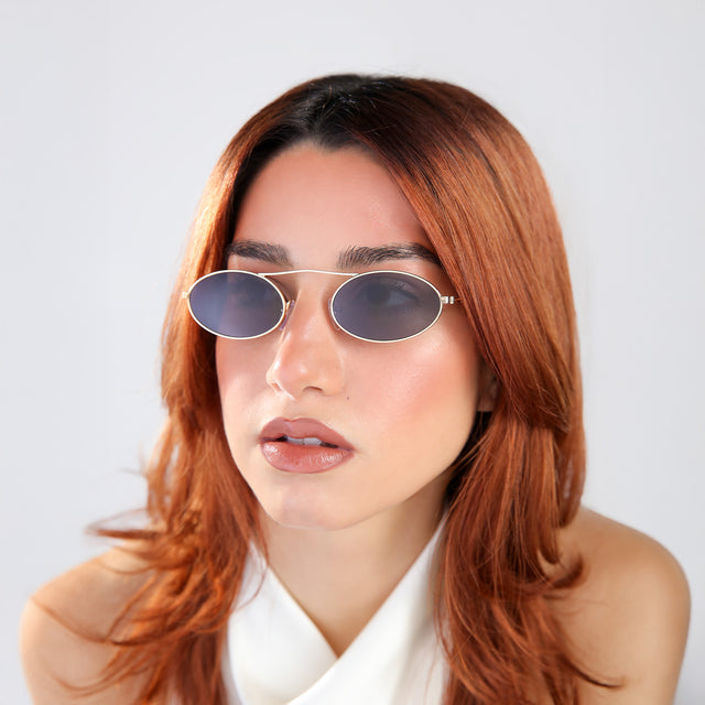 Another angle of woman with red hair in a white blouse wearing Sydney Sunglasses Gold with Grey