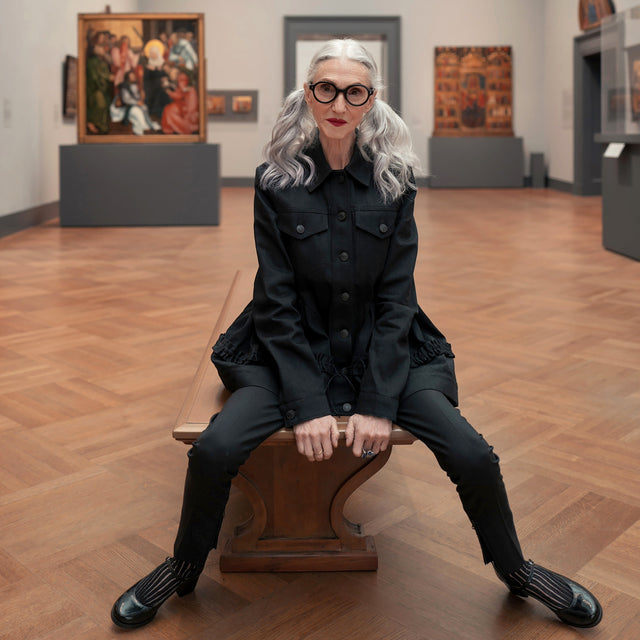 Model with silver hair at a Met Art Exhibit wearing The Met x illesteva Optical Black Optical