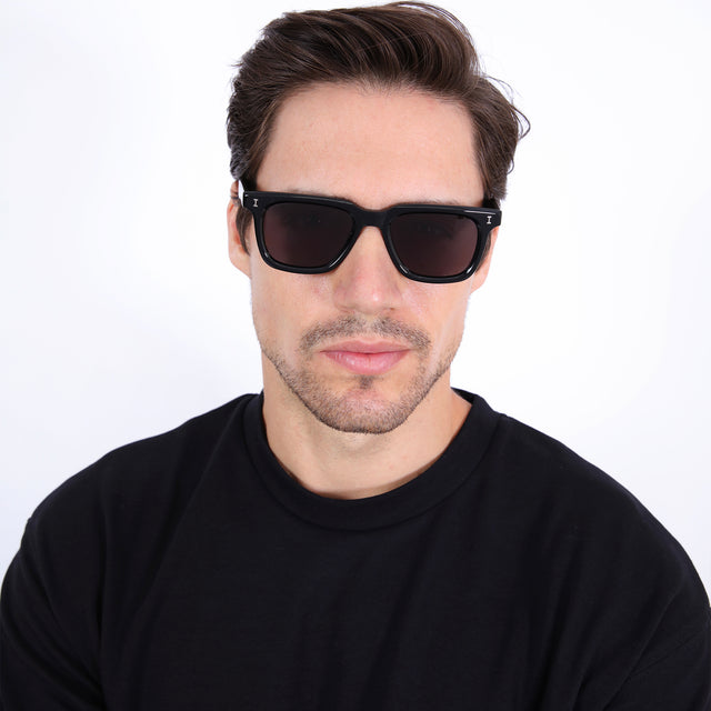 Model with brown hair combed sideways wearing Toscana Sunglasses Black with Grey