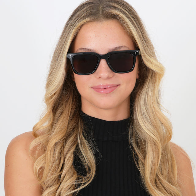 Blond model with curled hair wearing Toscana Sunglasses Black with Grey