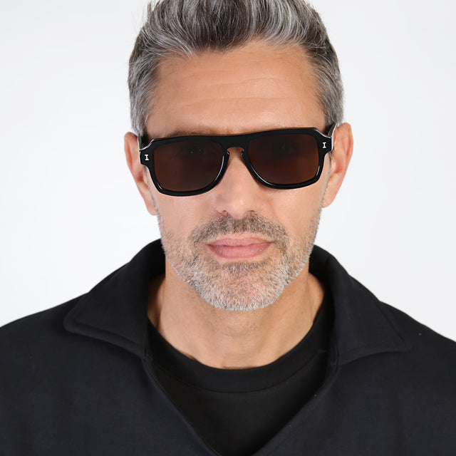 Model with salt and pepper hair and beard wearing Trancoso Sunglasses Black with Brown