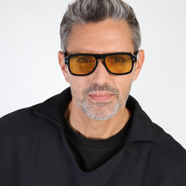 Model with salt and pepper hair and beard wearing Trancoso Sunglasses Black with Honey See Through