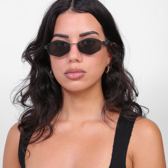 Brunette model with loose curls wearing Tucson Sunglasses Matte Black with Grey