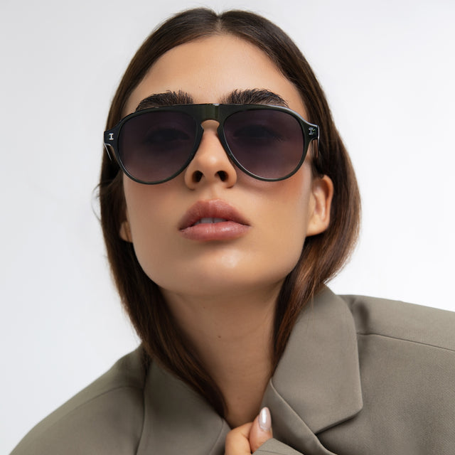 Woman in a blazer Vanderbilt Sunglasses front view in Pine with Grey Gradient