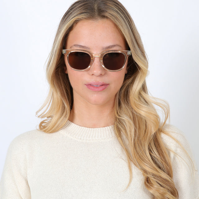 Blonde model with curled hair wearing Veneto Sunglasses Champagne with Brown Flat