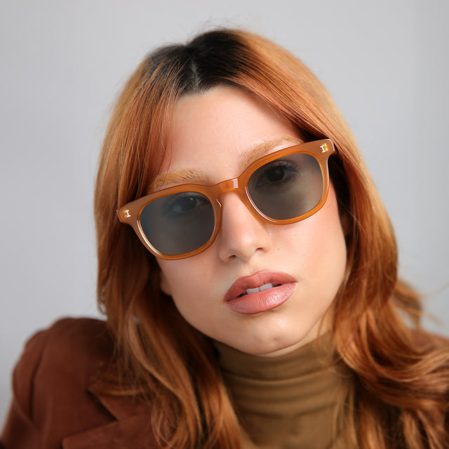 Another angle of model with red hair wearing Veneto Sunglasses Honey with Olive Flat