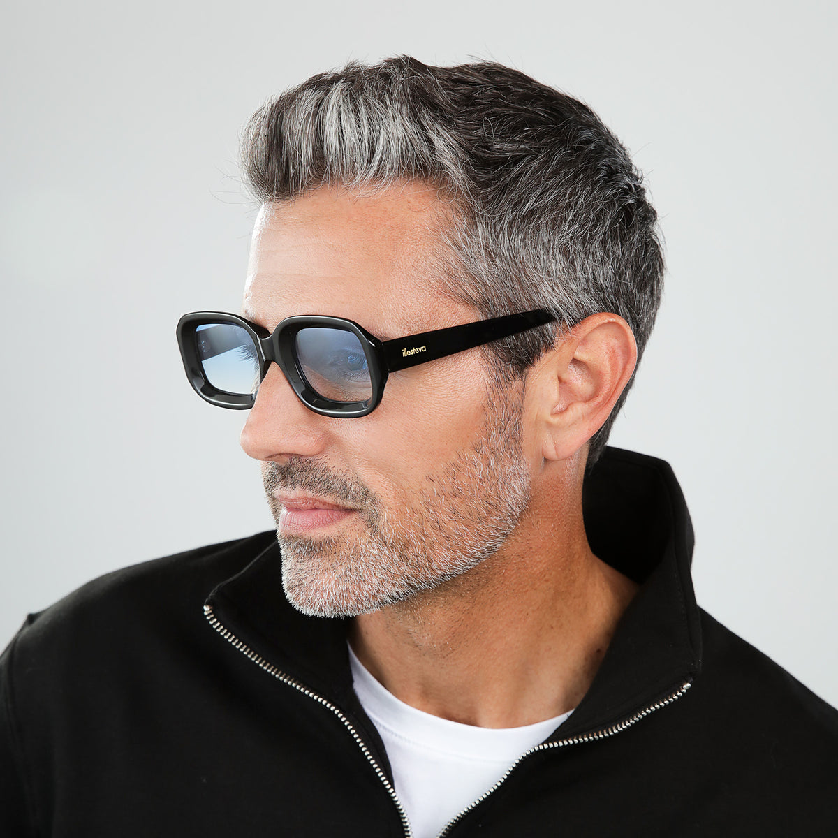 Man wearing Vinyl Sunglasses in Black with Blue Gradient See Through lenses, side profile, Model in a black sweatshirt looking to his right