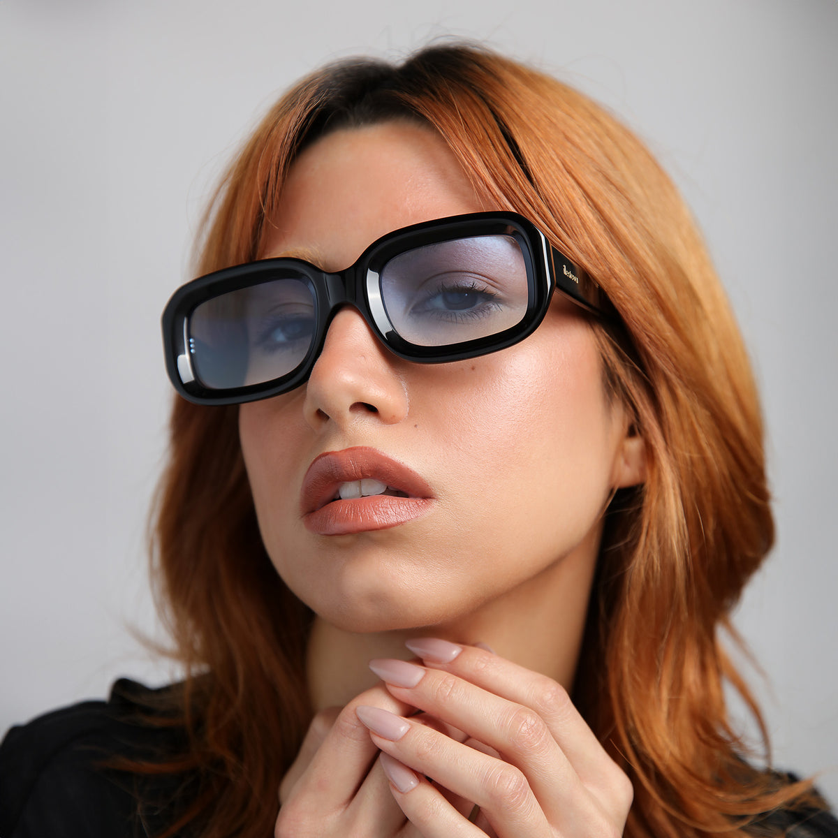 Woman wearing Vinyl Sunglasses in Black with Blue Gradient See Through lenses, Close up of model with red hair