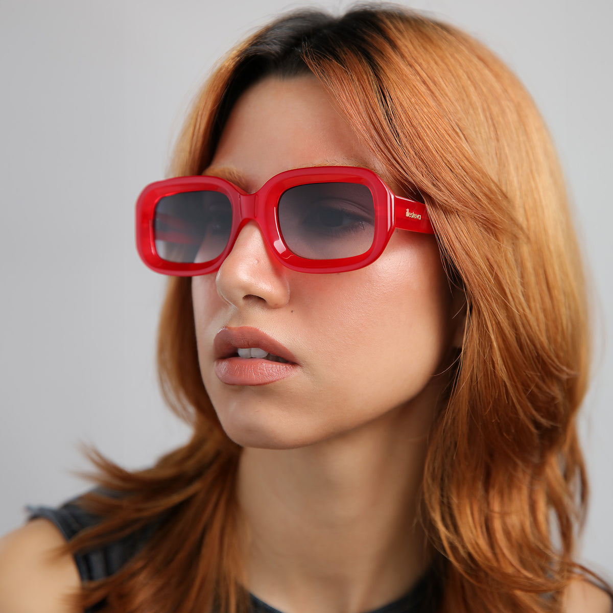 Woman wearing Vinyl Sunglasses in Red with Grey Gradient lenses, Another angle of model with red hair