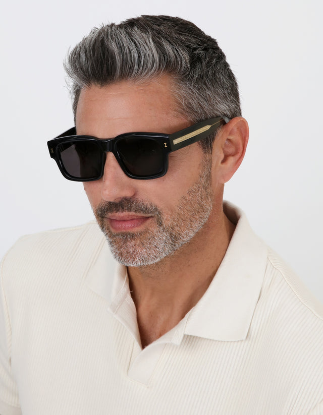 Model with salt and pepper hair and beard wearing Vito Sunglasses in Black/Gold with Grey lenses