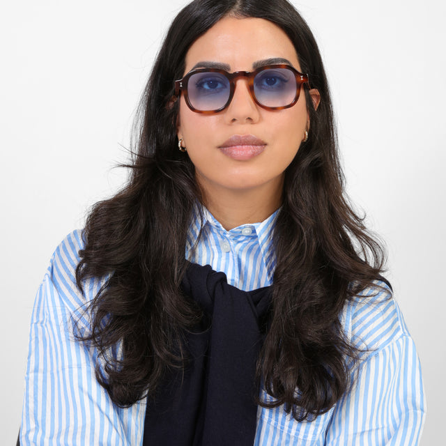 Brunette model wearing a blue and white striped blouse wearing Washington Sunglasses Havana with Blue Flat Gradient See Through