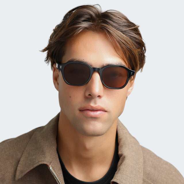 Man in a beige collared shirt wearing Will Sunglasses Black with Brown