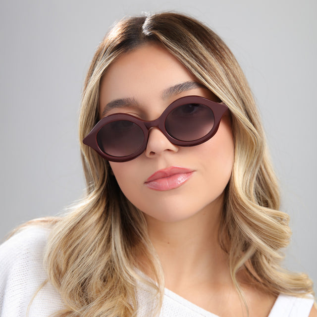 Blond woman in a white blouse wearing Willow Sunglasses Bordeaux with Grey Gradient
