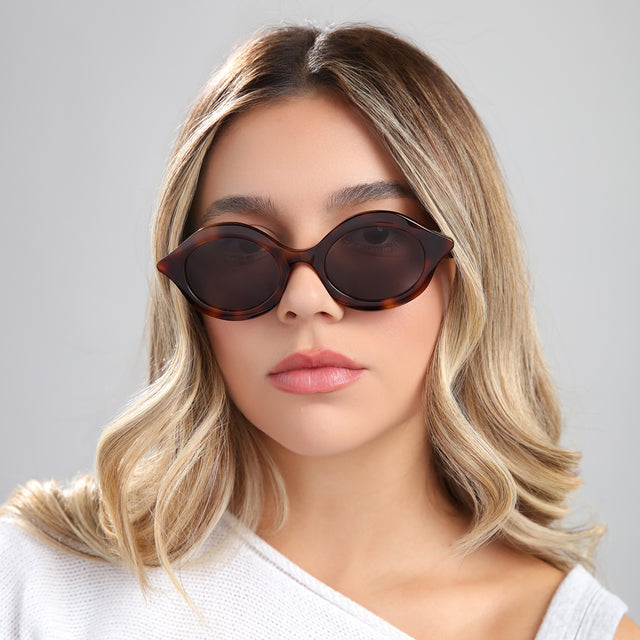 Another angle of blond woman in a white blouse wearing Willow Sunglasses Havana with Grey