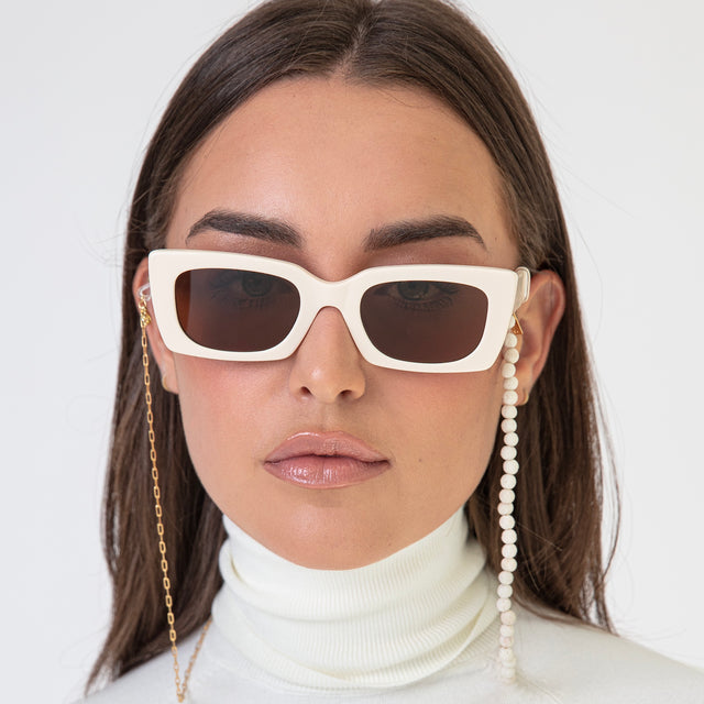 Brunette model with straight hair wearing Wilson Sunglasses Cream with Brown Flat