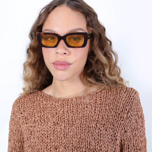 Brunette model with ombré, natural curls wearing Wilson Sunglasses Havana with Honey Flat See Through