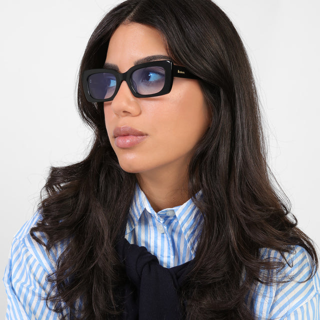 Brunette model looking right wearing Wilson Sunglasses Black with Blue Flat Gradient See Through