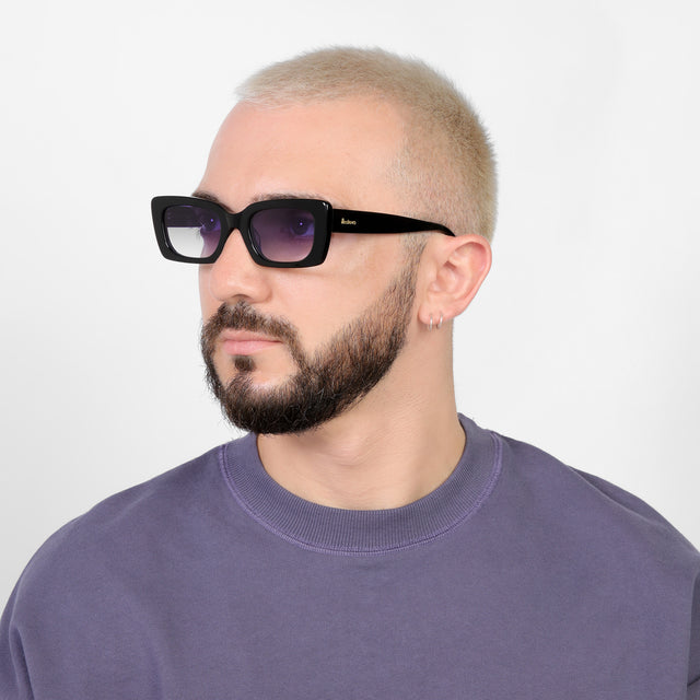 Bearded model looking right wearing Wilson Sunglasses Black with Purple Flat Gradient