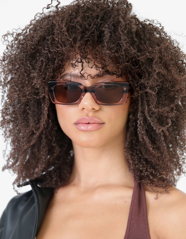 Brunette model with afro-curly hair wearing Wilson Sunglasses in Dusty Peach