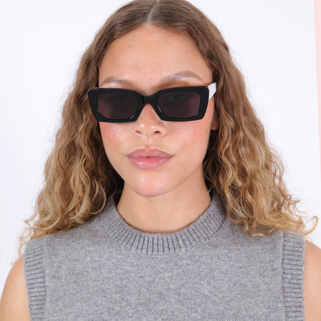 Brunette model with wavy ombre wearing nk x illesteva Wilson Sunglasses Black/White with Grey Flat