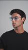 Man wearing the Eldridge Sunglasses in Clear with Blue Gradient See Through lenses while turning head