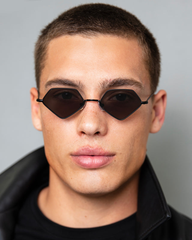 Model with buzzcut wearing Beak Sunglasses Matte Black with Grey Flat