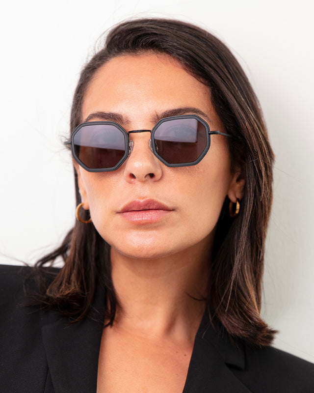 Brunette model with shoulder-length, straight hair wearing Dylan Tate Sunglasses Matte Black with Grey Flat Lenses