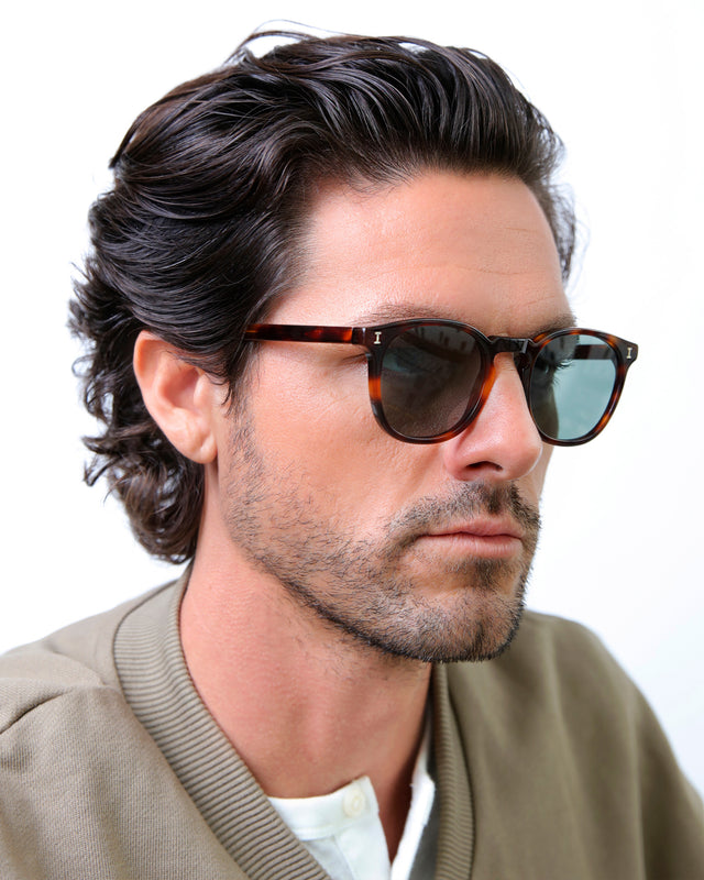 Model with semi short brown wavy hair wearing Eldridge Sunglasses Havana with Dark Olive Flat