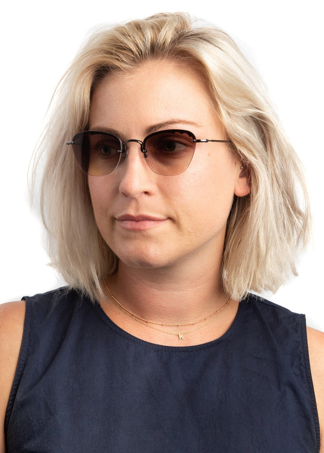 Blonde model with shoulder-length straight hair Sorrento Sunglasses side view in Gunmetal / Brown Flat Gradient Lenses