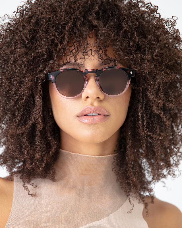 Brunette model with afro-curly hair wearing Leonard Sunglasses Cherry Blossom with Brown