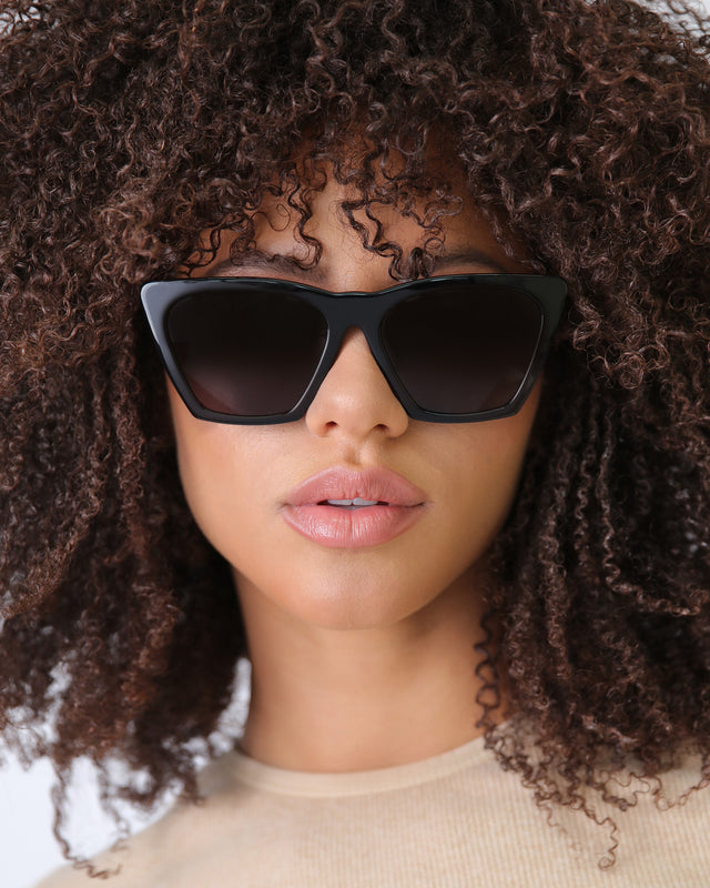 Model with curly hair wearing Lisbon 57 Sunglasses Black with Grey