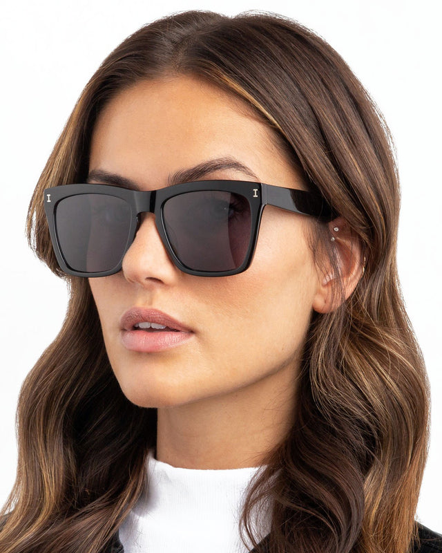 Brunette model with wavy hair wearing Los Feliz Sunglasses Black with Grey