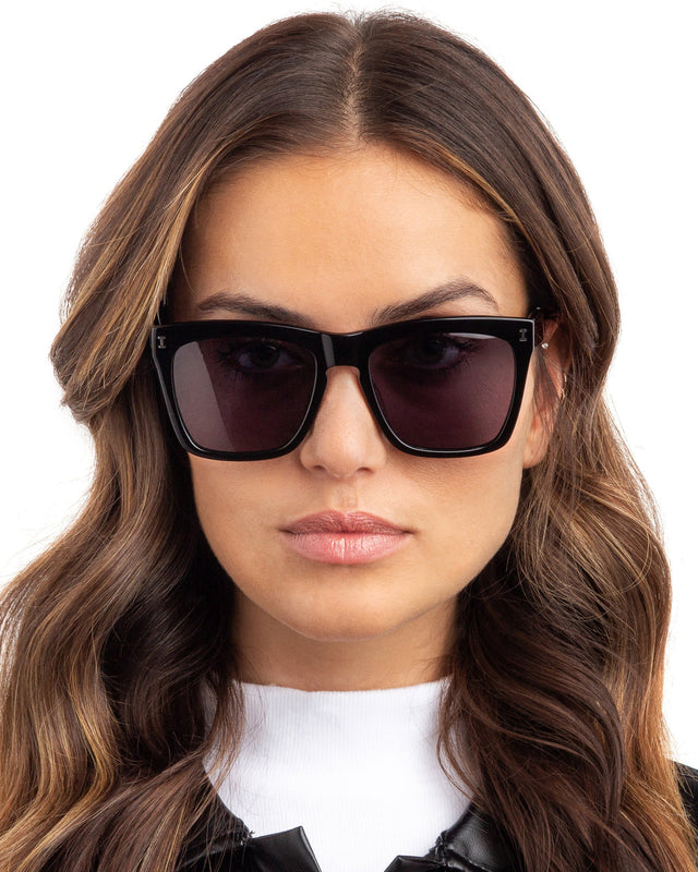 Brunette model with wavy hair wearing Los Feliz Sunglasses Black with Grey