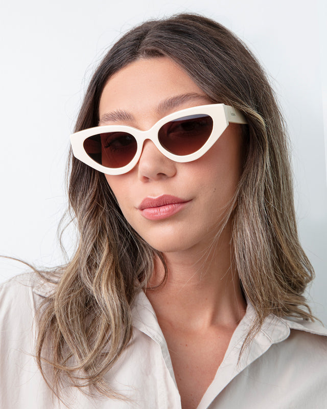 Brunette model with ombre wavy hair wearing Mary Lou Sunglasses Cream with Brown Flat Gradient