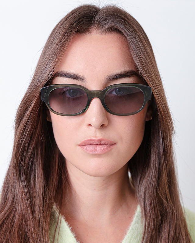 Brunette model with wavy hair wearing Montreal Sunglasses Pine with Grey Flat Gradient