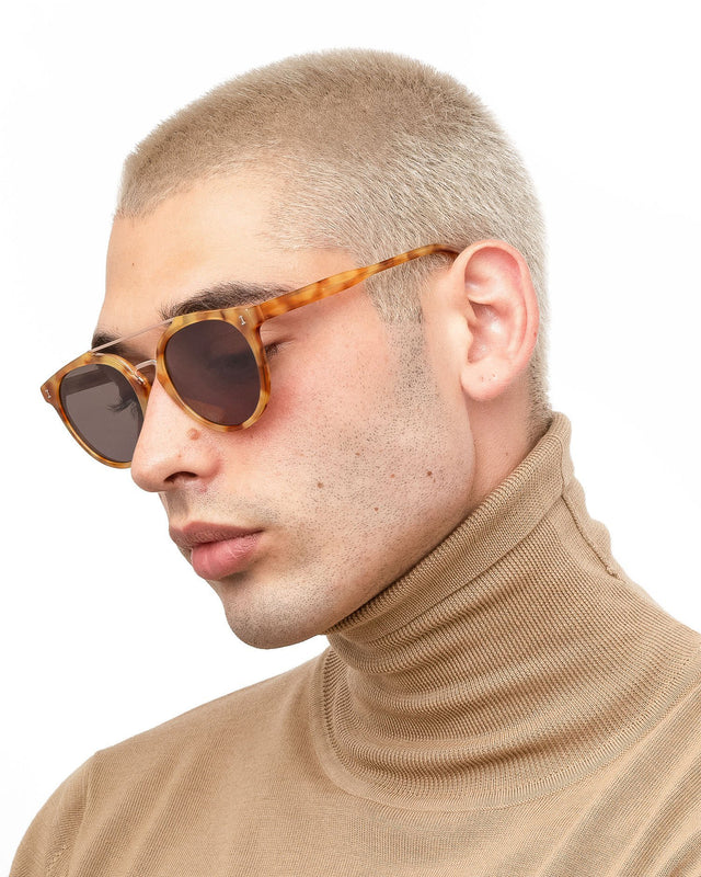 Model with blonde buzzcut wearing Puglia Sunglasses Amber/Rose Gold with Grey Flat