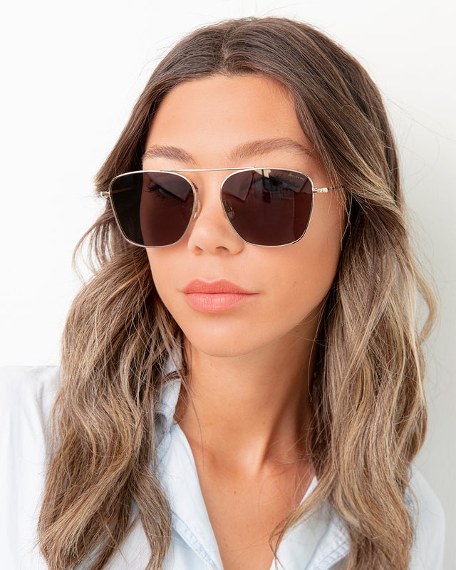 Brunette model with ombre wavy hair wearing Samos Sunglasses Gold with Grey Flat