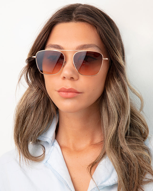 Brunette model with ombre wavy hair wearing Samos Sunglasses Rose Gold with Brown Flat Gradient