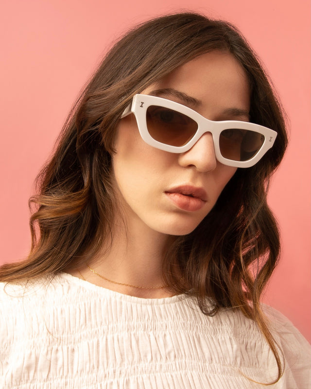 Brunette model with wavy hair wearing Donna Sunglasses White with Brown Gradient