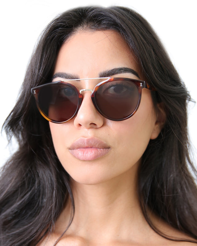 Brunette model with wavy hair wearing Puglia Sunglasses Havana/Gold with Grey Flat